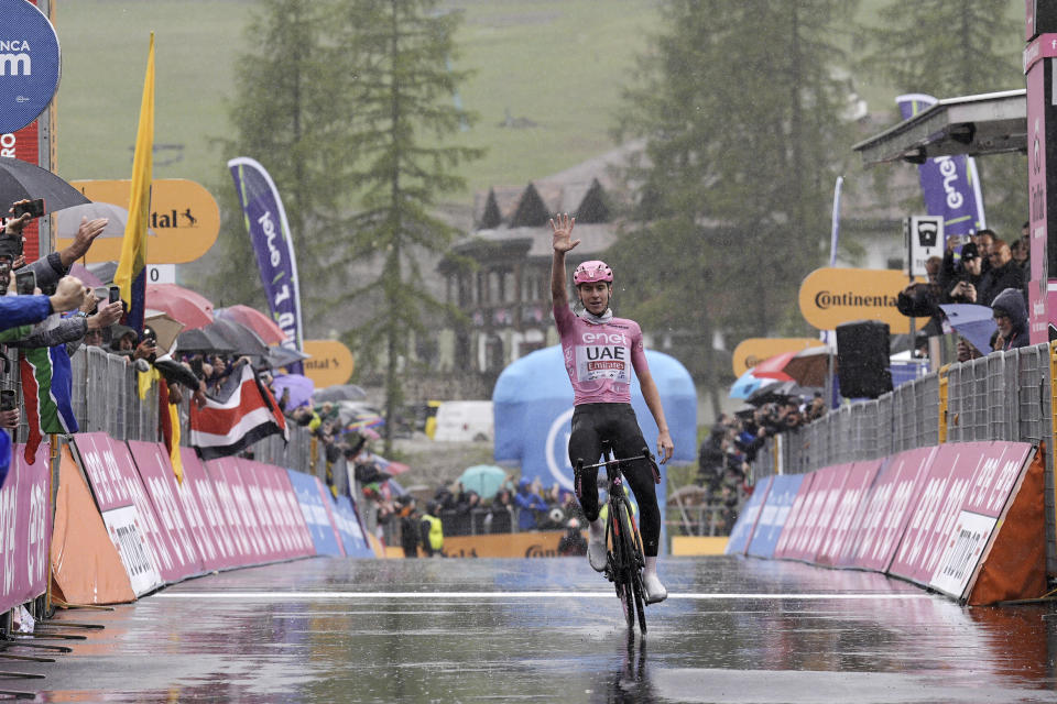 FILE - Slovenia's Tadej Pogacar, wearing the pink jersey of the race overall leader, indicates five, the numbers of Giro' stages he has won so far, as he crosses the finish line to win the 16th stage of the Giro d'Italia cycling race, from Livigno to Santa Cristina Val Gardena (Monte Pana), Italy, Tuesday, May 21, 2024. (Marco Alpozzi/LaPresse via AP, File)