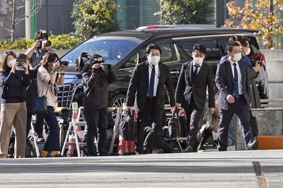 Investigators enter the headquarters of major advertising company Dentsu in Tokyo Friday, Nov. 25, 2022. Japanese prosecutors raided the headquarters of Dentsu Friday, as the investigation into corruption related to the Tokyo Olympics widened. (Kyodo News via AP)