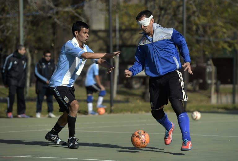 Blind paralympic football players Marcelo Panizza (R) dribbles around teammate Gustavo Maidana during a training session in Buenos Aires
