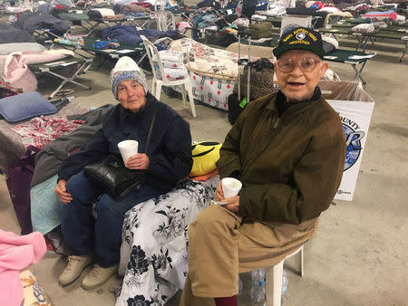 The couple Richard Seabold, 83, and Yvonne Seabold, 91, sit in an emergency shelter after leaving their home due to a wildfire in Ventura, California, U.S., December 8, 2017. REUTERS/Alex Dobuzinskis