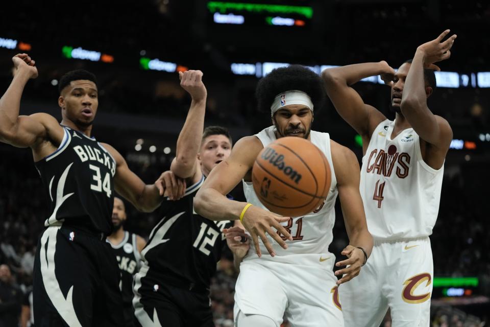 Cleveland Cavaliers' Jarrett Allen, Evan Mobley (4) and Milwaukee Bucks' Giannis Antetokounmpo (34) and Grayson Allen (12) go after a loose ball during the first half of an NBA basketball game Friday, Nov. 25, 2022, in Milwaukee. (AP Photo/Morry Gash)