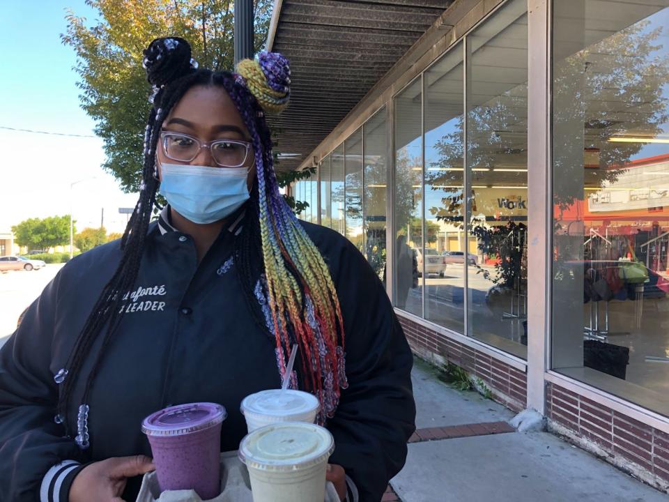 Shalafonte Walls carries beverages outside a store in Atlanta.