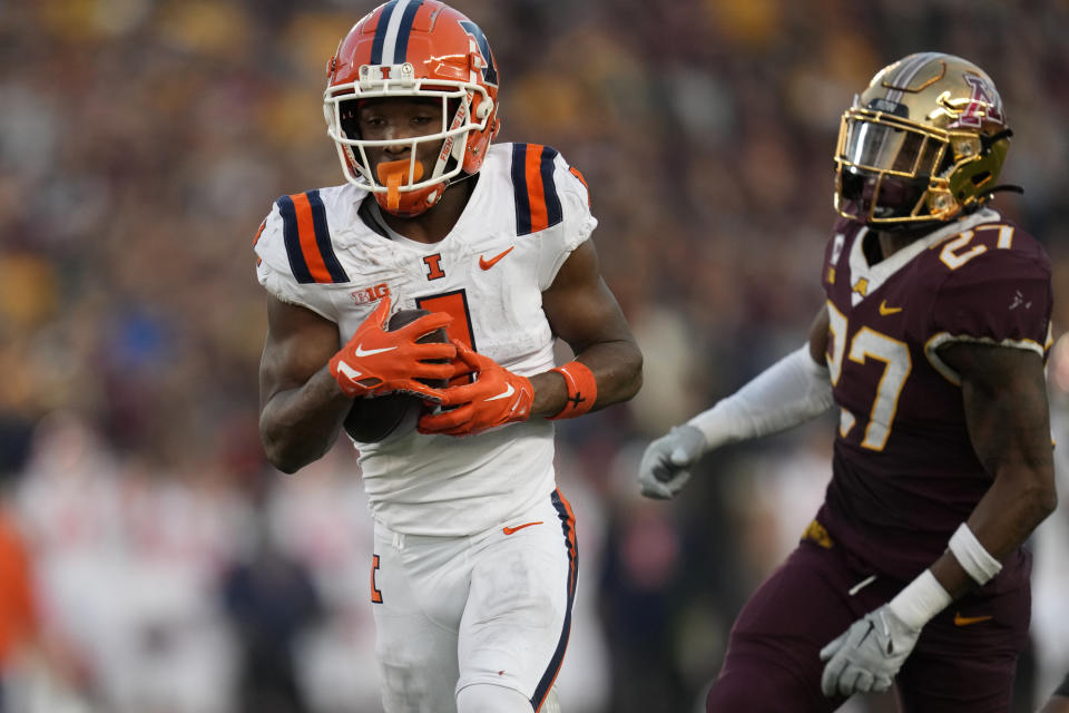 Illinois wide receiver Isaiah Williams (1) scores a 46-yard touchdown as Minnesota defensive back Tyler Nubin (27) defends during the second half of an NCAA college football game Saturday, Nov. 4, 2023, in Minneapolis. (AP Photo/Abbie Parr)