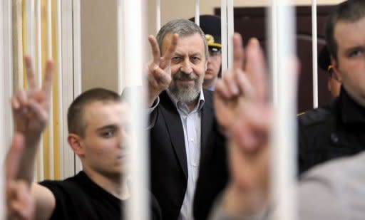 Belarus opposition leader Andrei Sannikov (centre) and supporters flash the V-sign for victory in the defendant's cage during his trial in Minsk. Belarus is facing an international outcry after jailing Sannikov, the main rival of autocratic President Alexander Lukashenko, for five years in a process denounced by the opposition as a political show trial