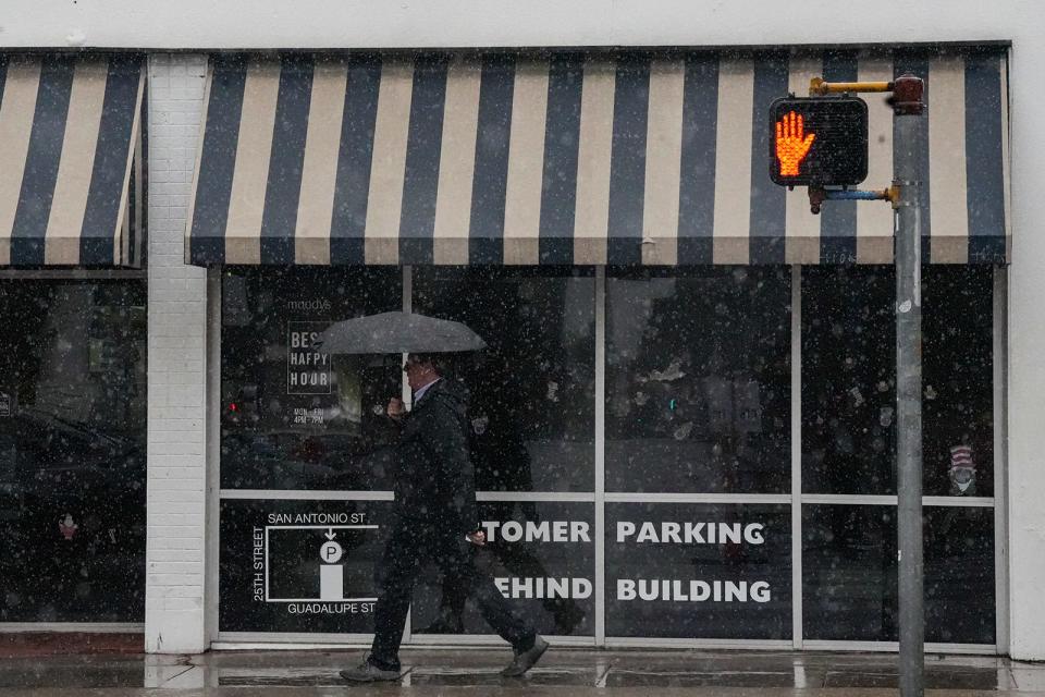 A man carries an umbrella as he walks in the rain along the Drag near the University of Texas on Dec. 19, which was the last time Austin got significant rainfall. So far in January, the city has logged only 0.07 inch of rain, but a pair of approaching cold fronts could bring needed moisture.