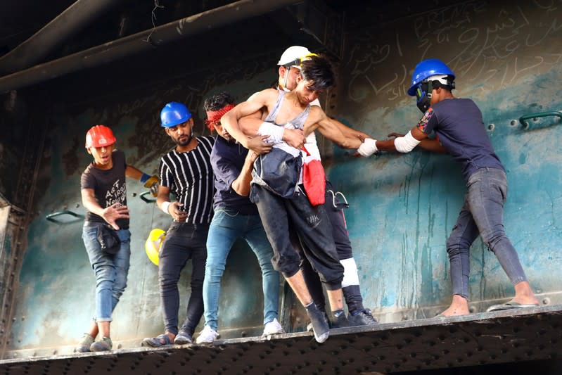 Iraqi demonstrators carry away a boy affected by tear gas during the ongoing anti-government protests in Baghdad