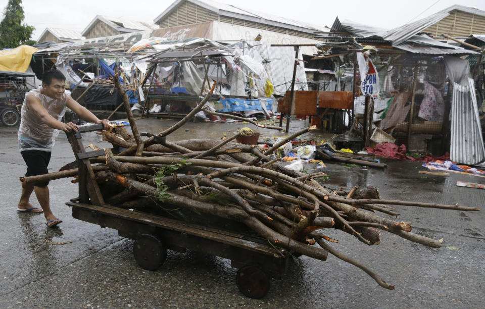 A resident pushes a cart full of wood as he passes market stalls destroyed by strong winds as Typhoon Mangkhut barreled across Tuguegrao city in Cagayan province, northeastern Philippines on Saturday, Sept. 15, 2018. The typhoon slammed into the Philippines northeastern coast early Saturday, it's ferocious winds and blinding rain ripping off tin roof sheets and knocking out power, and plowed through the agricultural region at the start of the onslaught. (AP Photo/Aaron Favila)