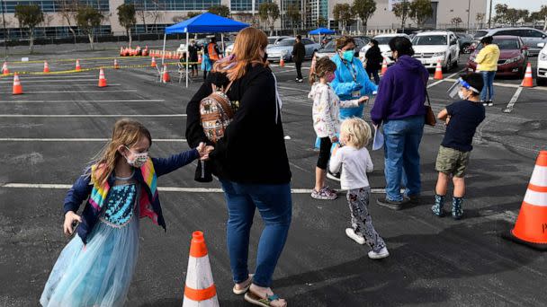 PHOTO: People with children sign up to receive rapid Covid-19 tests at a Long Beach Public Health Department testing site in the parking lot of a former Boeing aircraft factory, Jan. 10, 2022, in Long Beach, Calif. (Patrick T. Fallon/AFP via Getty Images)