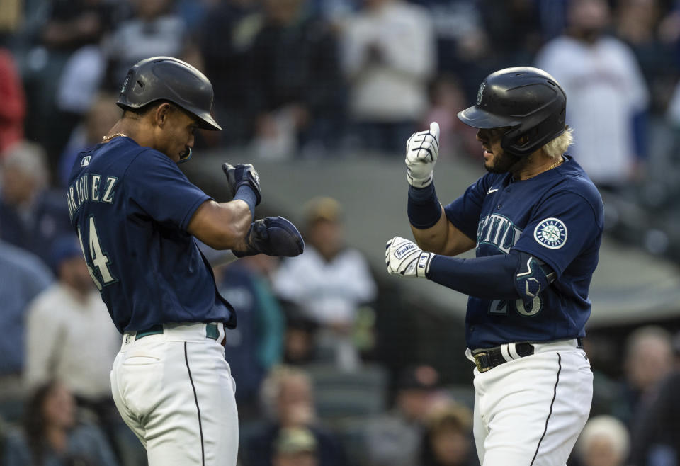 Seattle Mariners' Eugenio Suarez, right, celebrates with teammate Julio Rodriguez after hitting a two-run home run off Oakland Athletics starting pitcher Zach Logue during the fifth inning of a baseball game, Monday, May 23, 2022, in Seattle. Rodriguez also scored on the hit. (AP Photo/Stephen Brashear)