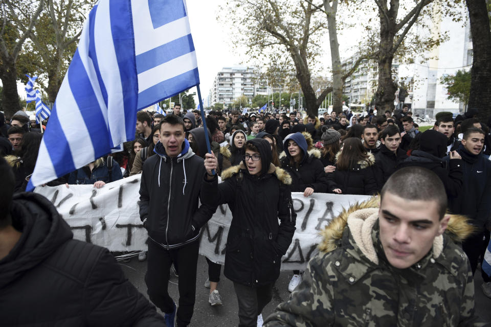 A teenager holds a Greek flag during a protest in the northern Greek city of Thessaloniki, Thursday, Nov. 29, 2018. About 1,000 high school students protested against government efforts to end a three-decade-old dispute with neighboring Macedonia. (AP Photo/Giannis Papanikos)