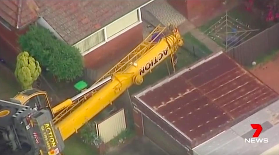 A crane came toppling down between a home and a garage in Sydney’s southwest. Source: 7 News