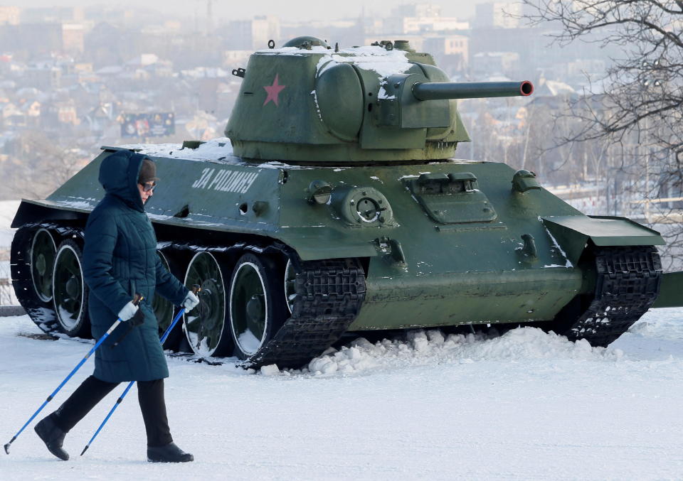 A woman passes by a T-34 tank and other Soviet-era military vehicles while walking in a park in the rebel-held city of Donetsk, Ukraine, January 27, 2022. / Credit: ALEXANDER ERMOCHENKO/REUTERS