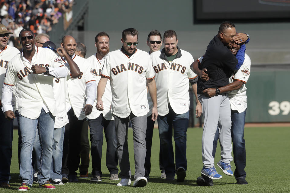 Los Angeles Dodgers manager Dave Roberts, second from left, hugs former San Francisco Giants player Barry Bonds during a ceremony honoring Giants manager Bruce Bochy after a baseball game between the Giants and the Dodgers in San Francisco, Sunday, Sept. 29, 2019. (AP Photo/Jeff Chiu, Pool)