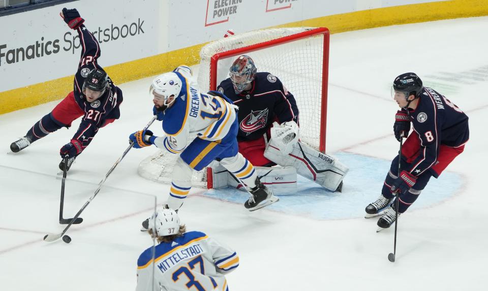 Columbus Blue Jackets defenseman Adam Boqvist (27) strives for the puck against Buffalo Sabres left wing Jordan Greenway (12) during first period action at Nationwide Arena.