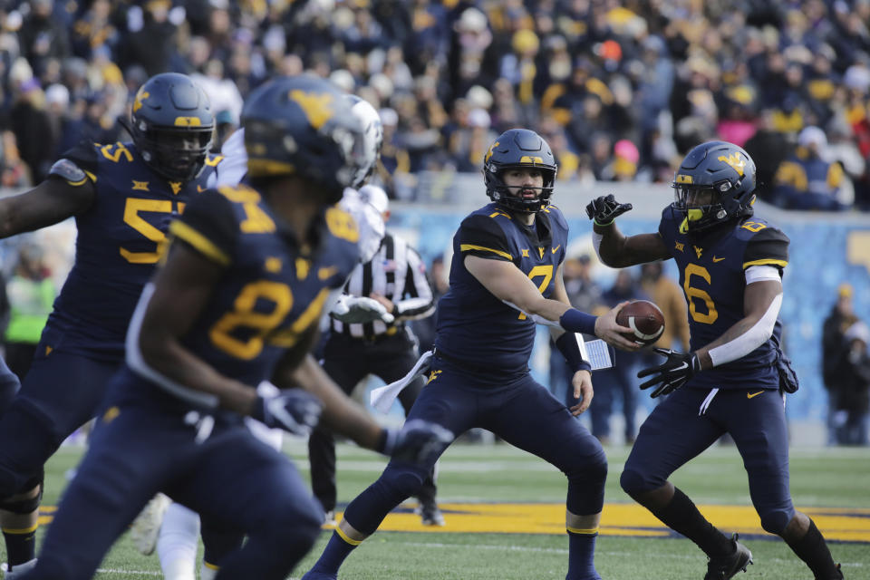 West Virginia quarterback Will Grier (7) hands the ball off to running back Kennedy McKoy (6) during the first half of an NCAA college football game against TCU, Saturday, Nov. 10, 2018, in Morgantown, W.Va. (AP Photo/Raymond Thompson)