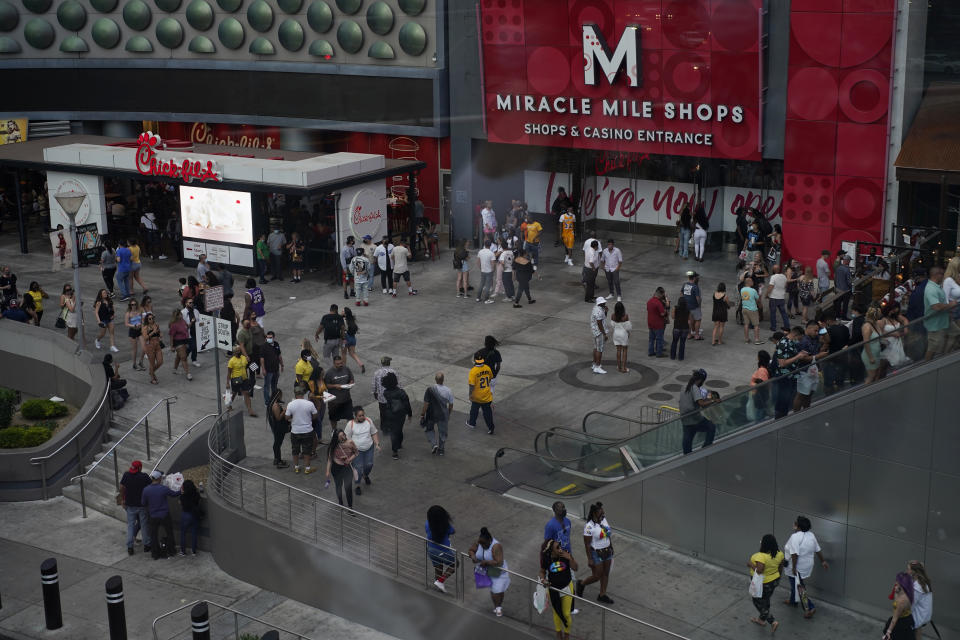 Crowds walk along the Las Vegas Strip, Saturday, April 24, 2021, in Las Vegas. On Saturday, May 1, casino capacity limits in Las Vegas increase to 80% and person-to-person distancing drops from 6 feet (1.8 meters) to 3 feet (0.9 meters). (AP Photo/John Locher)