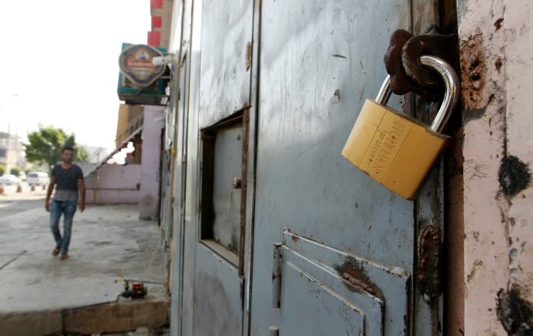 An Iraqi man walks past a closed liquor store in the capital Baghdad on October 23, 2016