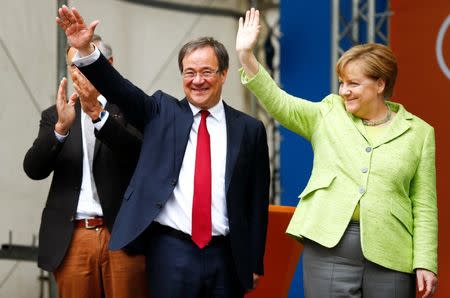 Armin Laschet, top candidate of conservative Christian Democratic Union (CDU) in North Rhine-Westphalia and German Chancellor Angela Merkel wave to supporters at an election rally in Aachen, Germany, May 13, 2017. REUTERS/Thilo Schmuelgen