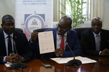 Haiti's Minister of Planning and External Cooperation Aviol Fleurant shows a statement, next to Minister of Interior and Territorial Communities Jean Marie Reynaldo Brunet (L) and Minister of Culture and Communication Joseph Guyler Delva, during a news conference about the resolution on the Oxfam scandal in Port-au-Prince, Haiti, June 13, 2018. REUTERS/Andres Martinez Casares