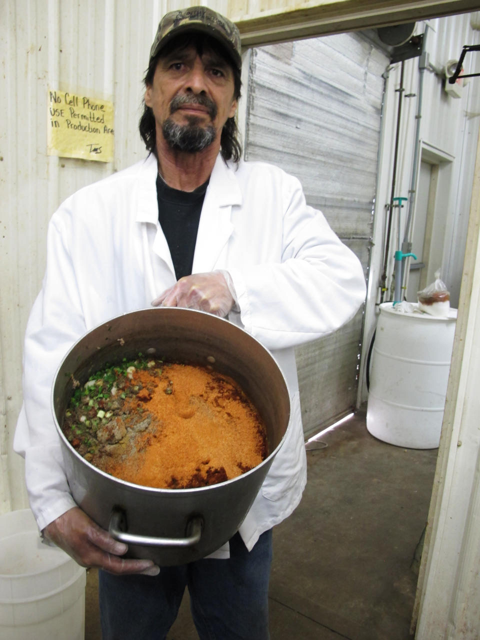 In this Wednesday, April 10, 2013 photo, William Brooks, a processor at the Country Store market, holds the pork and vegetable mixture to make boudin in Pennsdale, Pa. The sausage that also includes rice is popular in Louisiana. An influx of workers from the South to fill jobs in the natural gas industry in north-central Pennsylvania has led area catering businesses, restaurants and grocery stores to offer more Southern cuisine like jambalaya and boudin. (AP Photo/Genaro C. Armas)