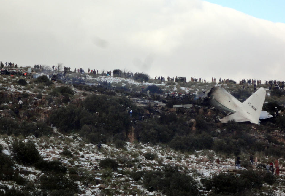 People look at the wreckage of Algerian military transport plane after it slammed into a mountain in the country’s rugged eastern region, Tuesday, Feb. 11, 2014. A civil defense official said 102 people on board were killed but one person managed to survive. The U.S.-built C-130 Hercules transport crashed about noon near the town of Ain Kercha, 50 kilometers (30 miles) southeast of Constantine, the main city in eastern Algeria. ( AP Photo/ Mohamed Ali)