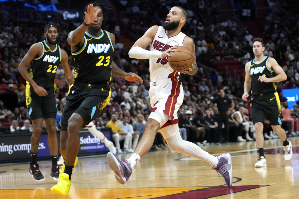 Miami Heat forward Caleb Martin (16) drives to the basket as Indiana Pacers forward Aaron Nesmith (23) defends during the first half of an NBA basketball game Saturday, Dec. 2, 2023, in Miami. (AP Photo/Lynne Sladky)