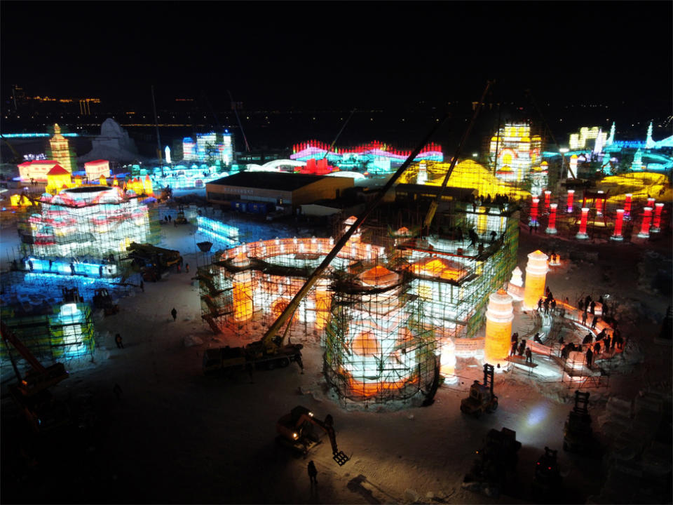 Workers build ice structures at night