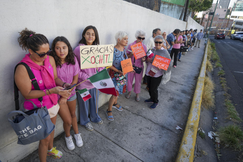 Votantes, algunos con un cartel de apoyo a la candidata presidencial de la oposición Xóchitl Gálvez, hacen fila afuera de un colegio electoral durante las elecciones generales en la Ciudad de México, el domingo 2 de junio de 2024. (AP Foto/Fernando Llano)