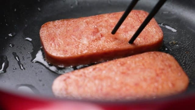 Frying luncheon meat slices with chopsticks