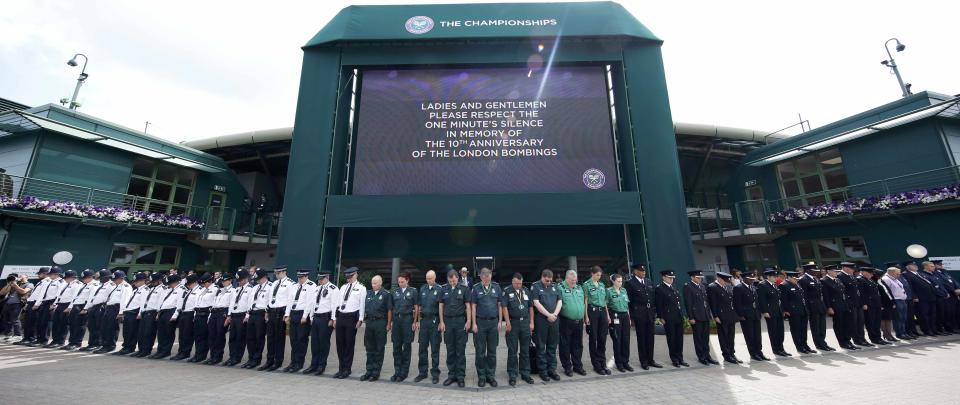 Members of the emergency services observe a minutes silence in memory of the 7/7 bombings in London at the Wimbledon Tennis Championships in London