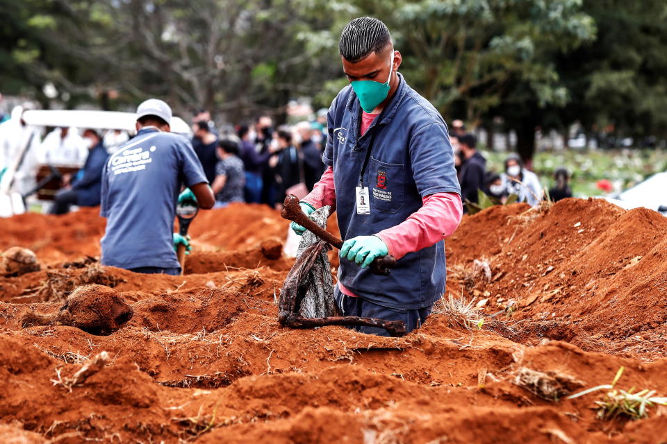 Gravediggers of the Vila Formosa cemetery, the largest in Latin America, exhume old graves to open new spaces for those deceased by Covid-19, in Sao Paulo, Brazil.