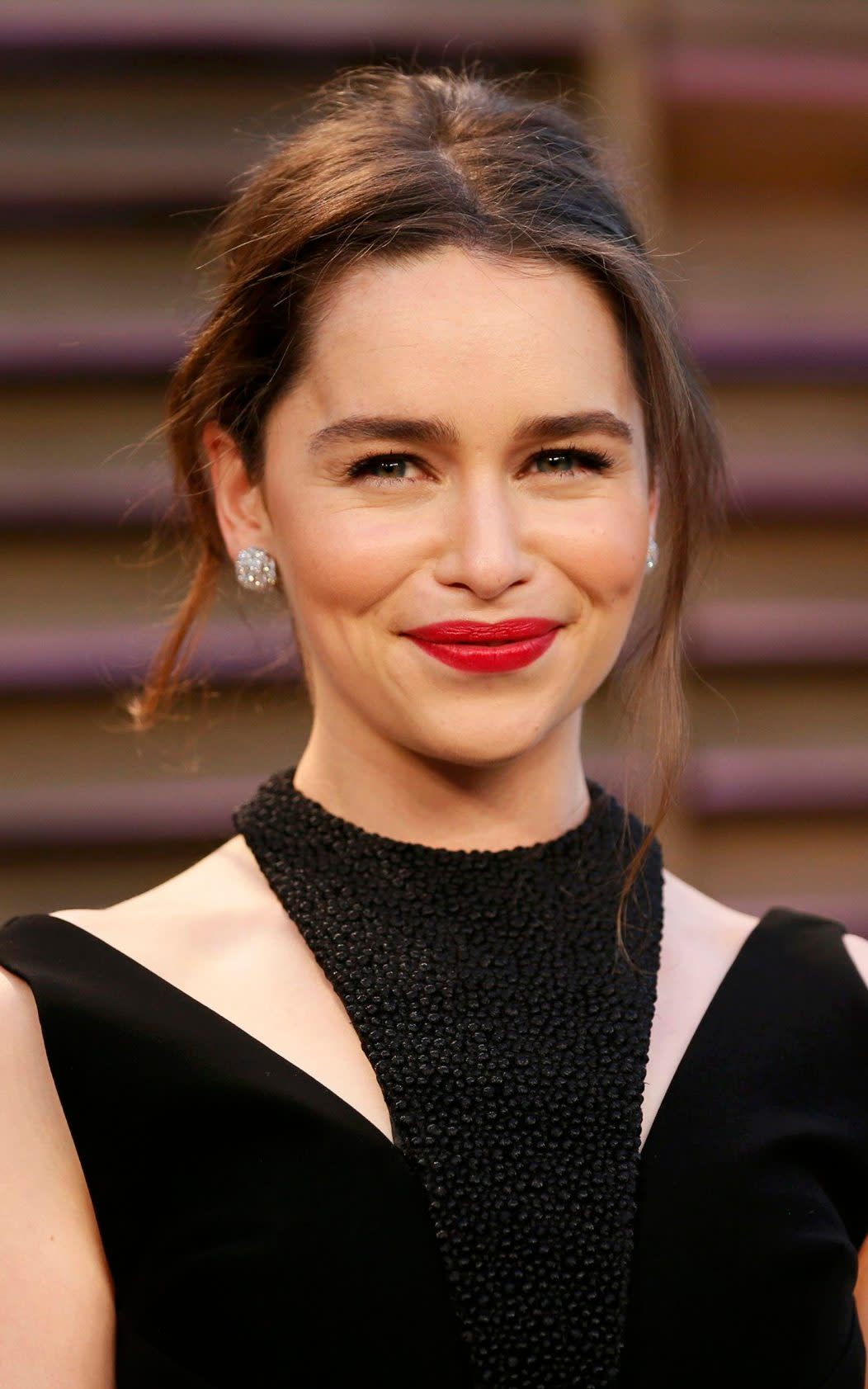 Emilia Clarke arrives at the 2014 Vanity Fair Oscars Party in West Hollywood with brown hair - Reuters