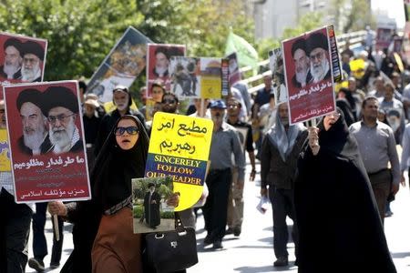 Iranian demonstrators carry posters depicting Iran's Supreme Leader Ayatollah Ali Khamenei and late Iranian leader Ayatollah Khomeini during a rally marking al-Quds (Jerusalem) Day in Tehran July 10, 2015. REUTERS/Stringer/TIMA