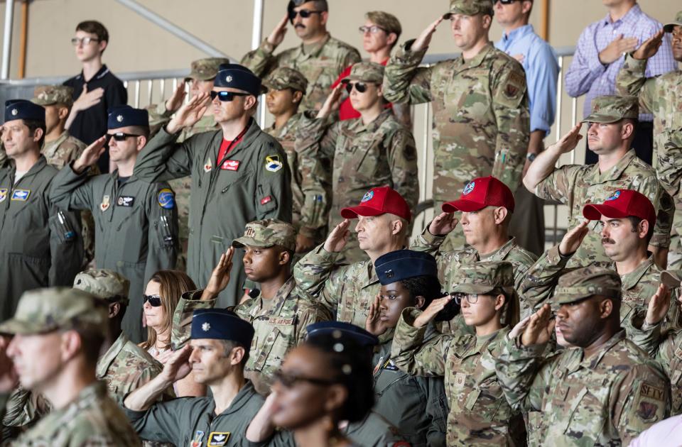 Service members salute during the national anthem during the change of command ceremony for the 325th Fighter Wing at Tyndall Air Force Base on Friday.