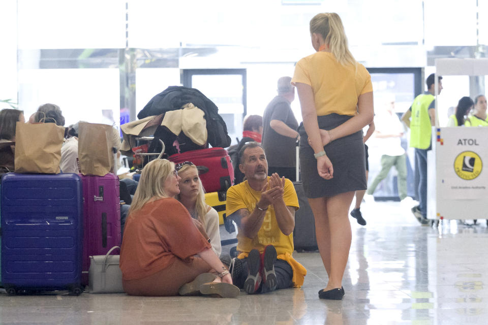 British passengers speak with Thomas Cook staff at Palma de Mallorca airport on Monday Sept. 23, 2019. Spain's airport operator AENA says that 46 flights have been affected by the collapse of the British tour company Thomas Cook, mostly in the Spanish Balearic and Canary archipelagos. (AP Photo/Francisco Ubilla)