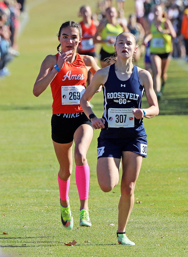Ames sophomore Claire Helmers (269) and Des Moines Roosevelt senior Abi Hahn (307) battle on the home stretch during the 4A girls race at the state co-ed cross country meet held at the Lakeside Municipal Golf Course at Kennedy Park in Fort Dodge Saturday. Helmers placed seventh individually to earn a medal.