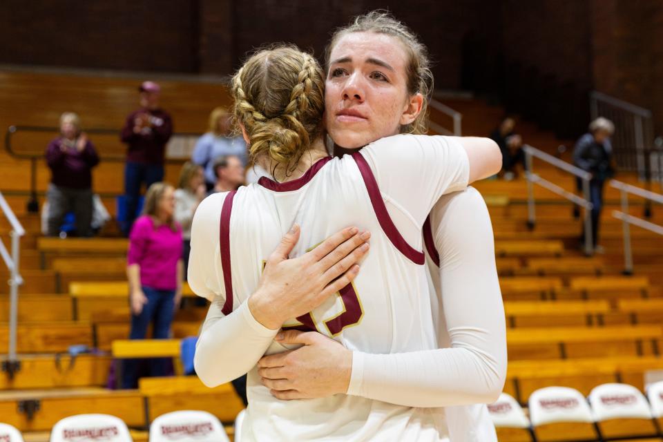 Willamette's Ava Kitchin (42) hugs Willamette's Elyse Waldal (33) after losing the NWC semifinal game at Cone Field House on Friday, Feb. 23, 2024, in Salem, Ore.
