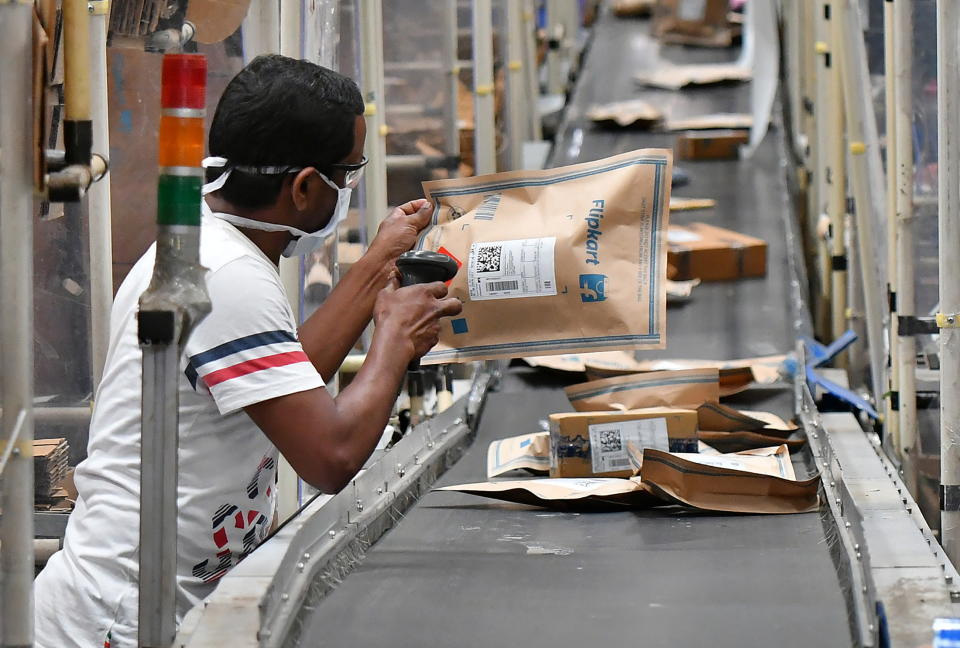 A worker at Flipkart, a leading e-commerce firm in India, scans a package on a conveyor belt inside its fulfilment centre on the outskirts of Bengaluru, India, September 23, 2021. REUTERS/Samuel Rajkumar