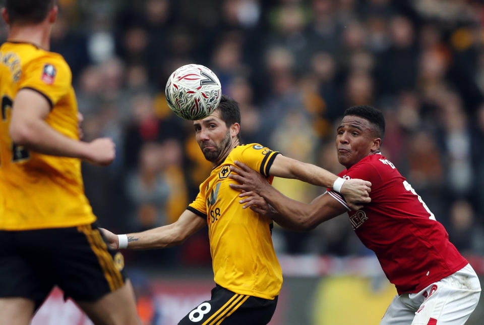 Wolverhampton's Joao Moutinho fights for the ball with Bristol City's Niclas Eliasson, right, during the English FA Cup fifth round soccer match between Bristol City and Wolverhampton Wanderers at Ashton Gate stadium in Bristol, England, Sunday, Feb. 17, 2019. (AP Photo/Frank Augstein)