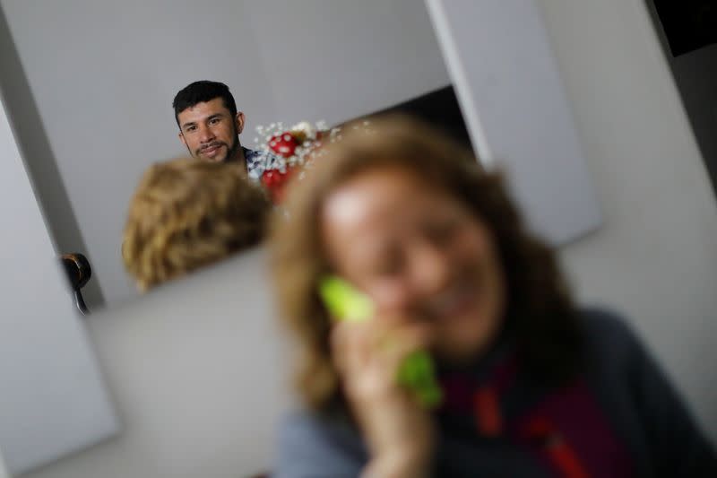 Anthony Vazquez from Venezuela sits with his cousin Geimy Garcia from Colombia in his relatives' house in Bogota