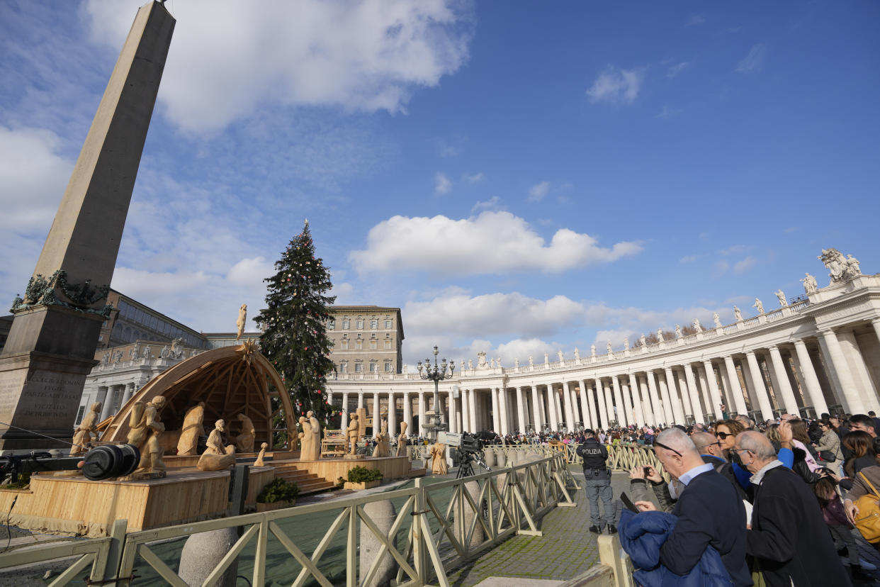 People pause in St. Peter's Square at The Vatican, Saturday, Dec. 31, 2022. Pope Emeritus Benedict XVI, the German theologian who will be remembered as the first pope in 600 years to resign, has died, the Vatican announced Saturday. He was 95. (AP Photo/Andrew Medichini)