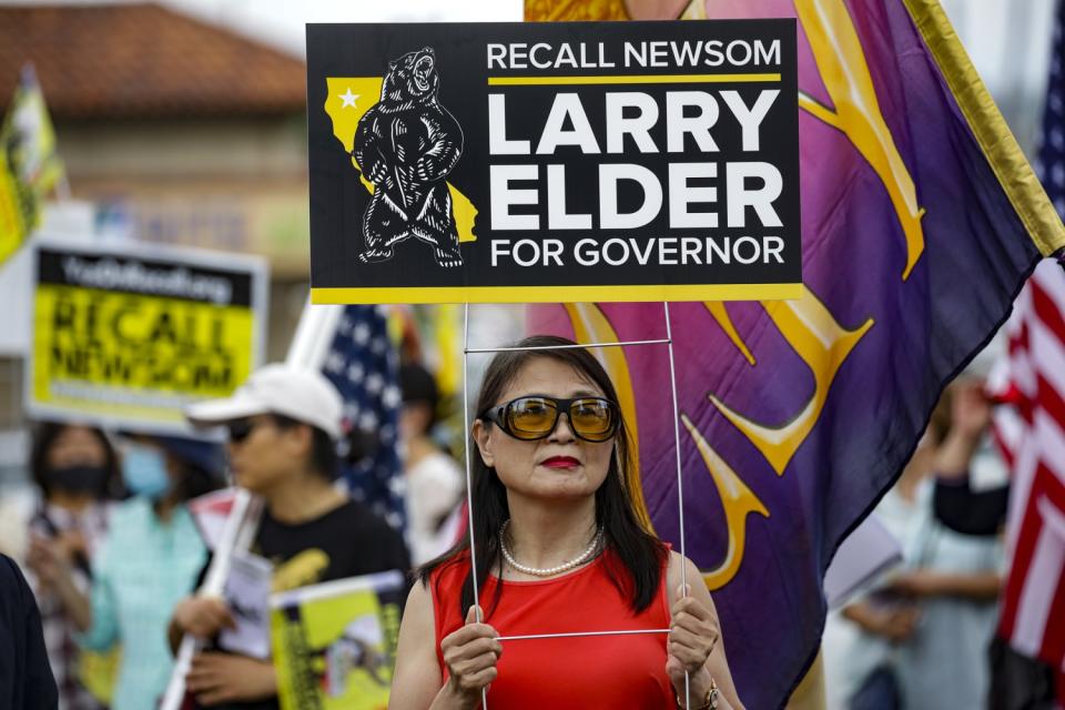 Recall supporters hold signs at a rally