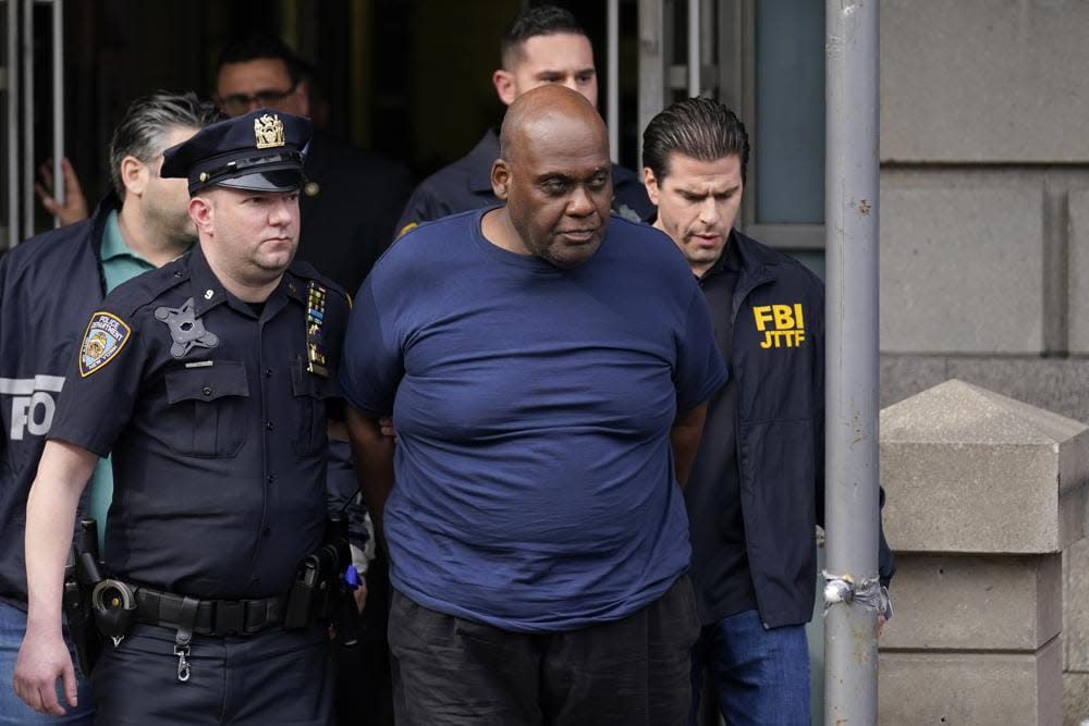 New York City Police and law enforcement officials lead subway shooting suspect Frank R. James, 62, center, away from a police station, in New York, Wednesday, April 13, 2022. (AP Photo/Seth Wenig)