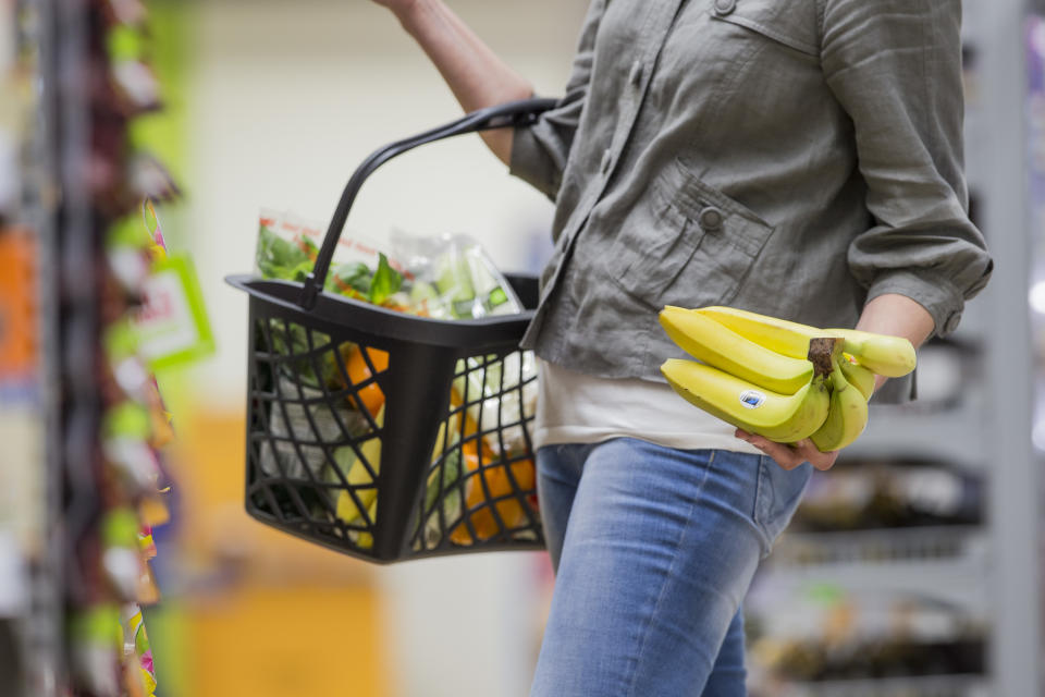 A supermarket shopper chooses a bunch of Fairtrade bananas.