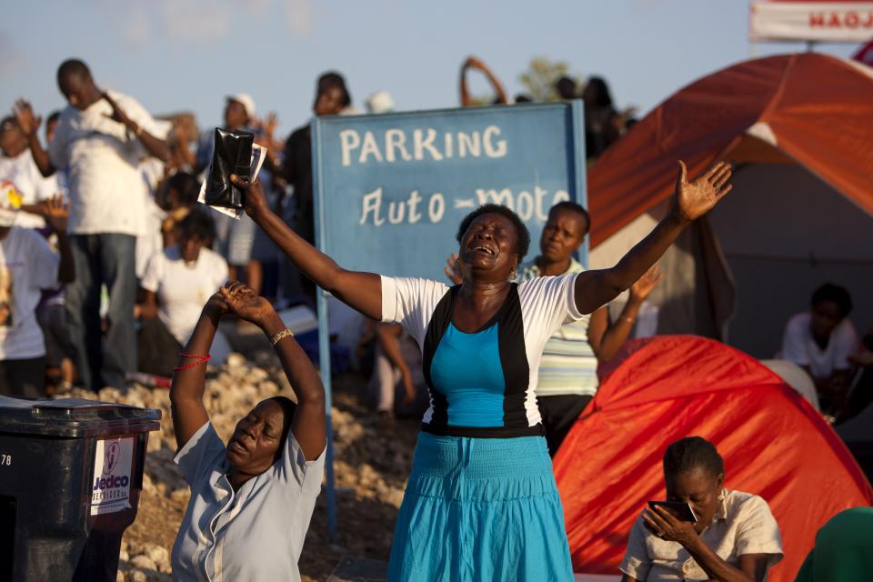 In this Feb. 8, 2014 photo, a Christian pilgrim cries as she prays at a religious gathering organized by Our Lady of Fatima Bible Center in the village of Bois-Neuf, Haiti. Although the center is Roman Catholic, the event had an evangelical feel, and some elements of Voodoo. (AP Photo/Dieu Nalio Chery)