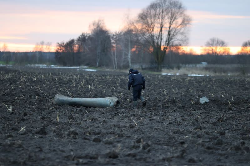 An investigator walks near a fragment of a munition in the Grodno region