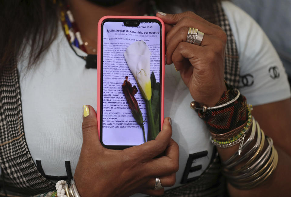 Community leader Luz Nelly Santana shows one of the many death threats she has received in Bogota, Colombia, Thursday, Dec. 17, 2020. The Afro-Colombian community leader sometimes uses a hat or a turban to disguise herself and always wears a bulletproof vest. (AP Photo/Fernando Vergara)