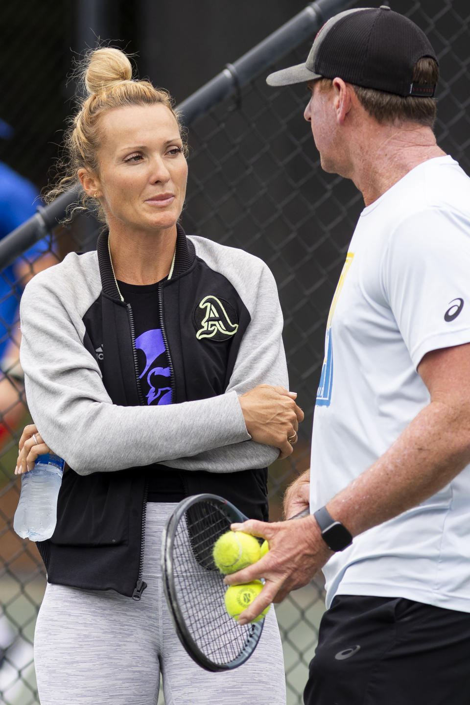 Iris Harris talks with coach Chris Tontz on a practice court at the Charleston Open tennis tournament in Charleston, S.C., Monday, April 3, 2023. Harris joined the women's professional tennis tour's Coach Inclusion Program to learn more about coaching a pro, yes, but also to make contacts that could lead to that chance. (AP Photo/Mic Smith)