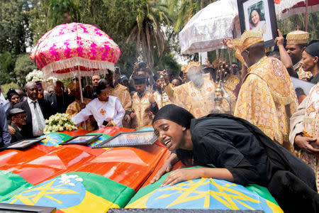 A woman mourns next to coffins during the burial ceremony of the Ethiopian Airline Flight ET 302 crash victims at the Holy Trinity Cathedral Orthodox church in Addis Ababa, Ethiopia, March 17, 2019. REUTERS/Maheder Haileselassie