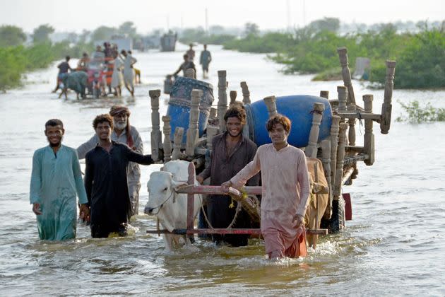 Stranded people along with their belongings wade through a flooded street after fleeing from their flood hit homes following heavy monsoon rains at Sohbatpur area in Jaffarabad district of Balochistan province on Aug. 28, 2022. Pakistan's flooded southern Sindh province braced on August 28 for a fresh deluge from swollen rivers in the north as the death toll from this year's monsoon topped 1,000. (Photo: FIDA HUSSAIN/AFP/Getty Images)